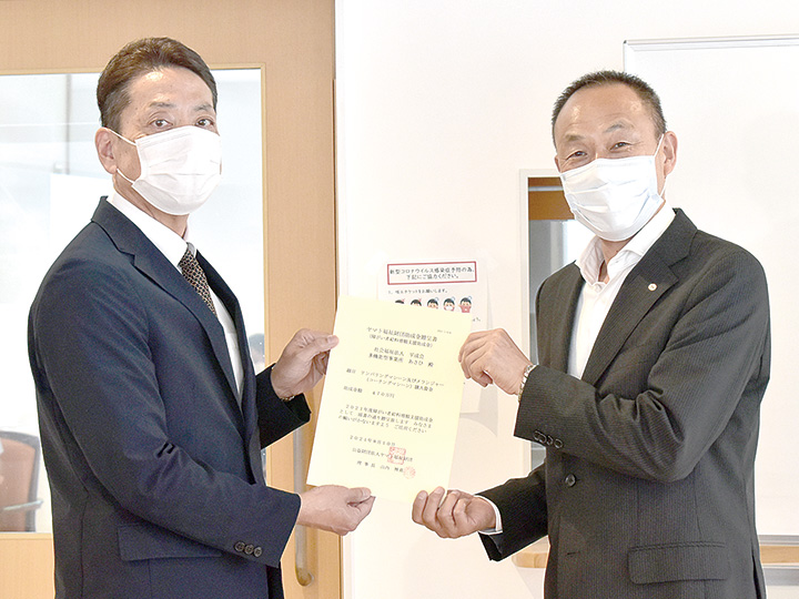 贈呈書を手にする小林執行役員（右）と斎藤施設長