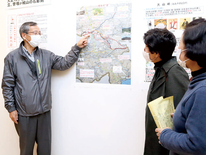 来場者に資料の説明をする角谷実行委員長