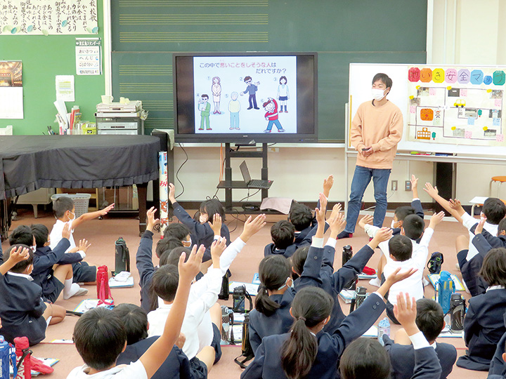 事前学習で比治山大学の学生の話を聞く児童
