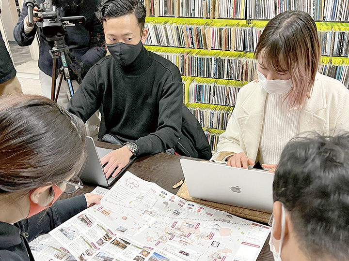 酒蔵通りの案内地図を見ながら打ち合わせをする音声ガイドの収録参加者（撮影・林）