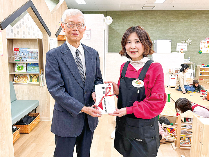 寄付金の目録を手にする今岡部会長（左）と市川代表理事（撮影・林）