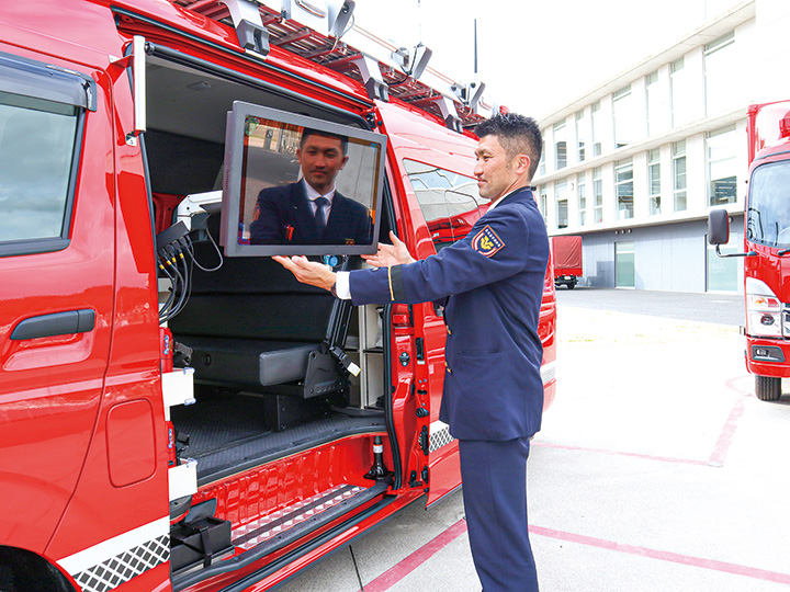 指揮統制車に搭載されたモニターを紹介する職員（撮影・山北）