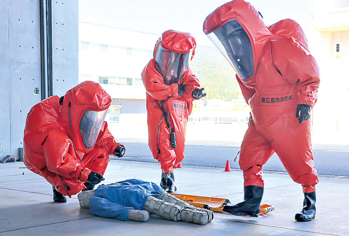 陽圧式化学防護服を着て、被災者の搬送訓練を行う隊員（撮影・山北）