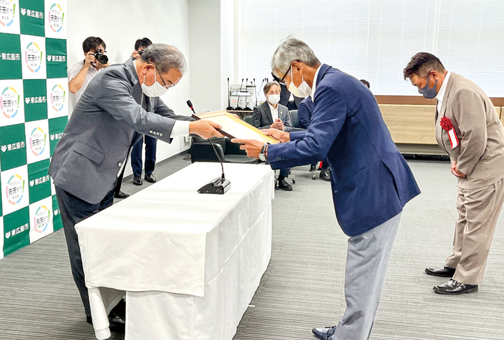 高垣広徳市長(左)から表彰状を受け取る建設事業者(撮影・林)
