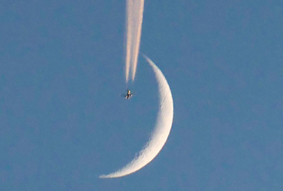 三日月をかすめる飛行機雲