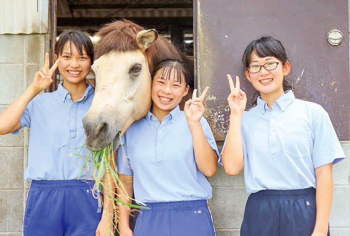 馬のマックと笑顔で写真に納まる(左から)愛甲さん、小林さん、蔦さん(撮影・山北)