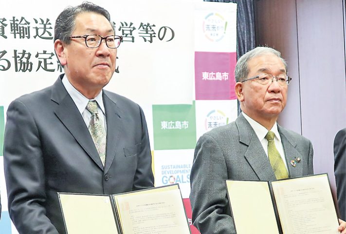 協定書を手に記念撮影する畦社長(左)と高垣市長(撮影・山北)