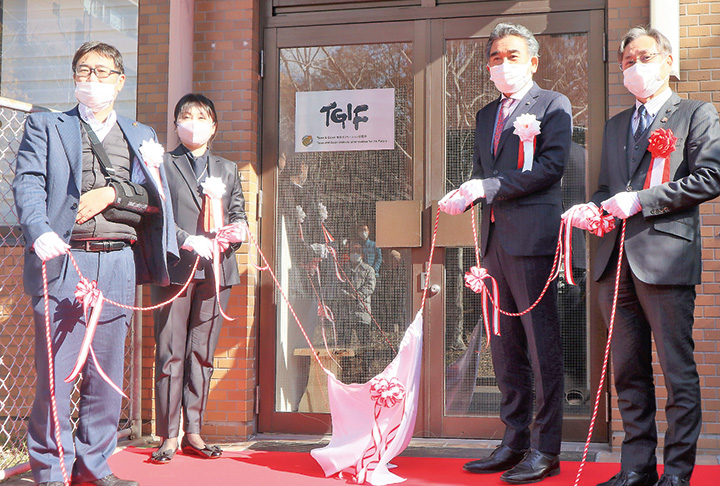 幕を引いて看板を披露する（左から）金子慎治理事・副学長、三好所長、越智学長、多田稔副市長（撮影・山北）