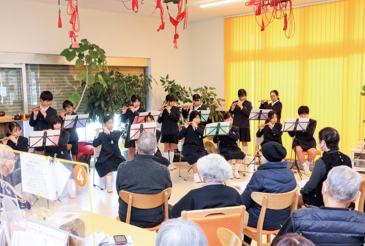 福祉施設利用者の前で篠笛を演奏する児童（撮影・山北）