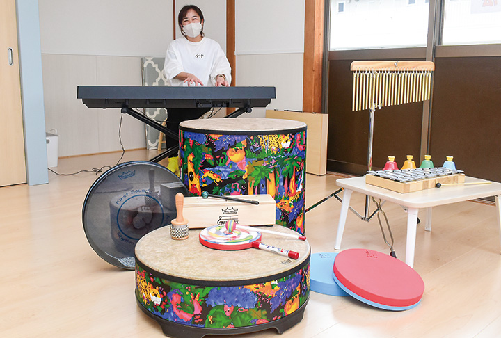 事業所内に多数置かれている楽器。中央は指導する狩谷さん（撮影・小林）