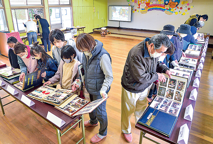 アルバムを閲覧する地域住民や卒園者