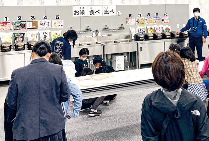 お米の食べ比べコーナーで説明を聞く参加者(撮影・生野)