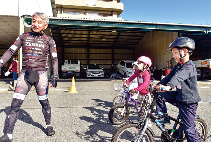 参加した子どもたちに自転車の乗り方を指導する片山さん（左）＝2022年（提供写真）