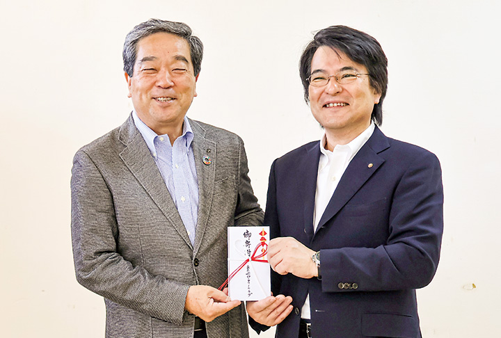 寄付金を手に持つ立川会長（右）と松尾会長（撮影・𦚰）