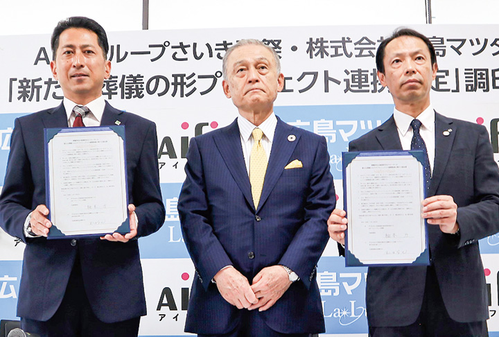 木原和由会頭（中央）が立ち合い、協定書を披露する柚木社長（左）と梯社長（撮影・山北）