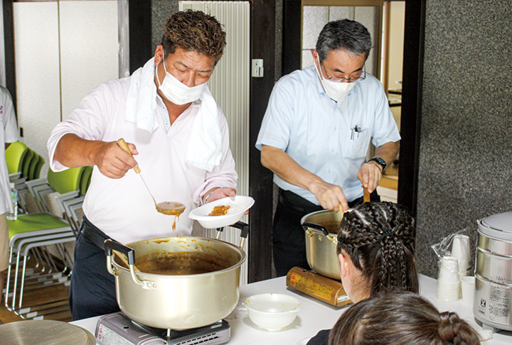 子どもたちにカレーをふるまう西条ロータリークラブのメンバー（撮影・高藤）