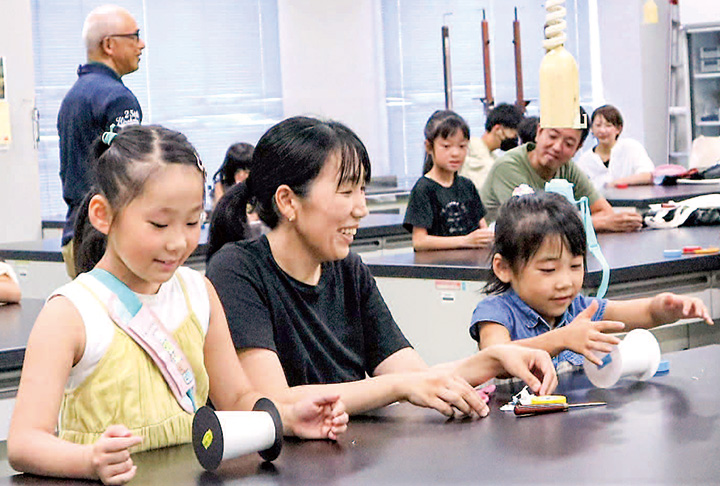 紙コップで動く車を作り、動かして楽しむ参加者（撮影・山北）