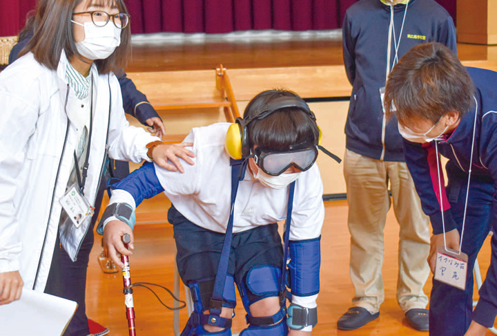 ゴーグルや重りなどを装着し、つえをついた歩行を体験する児童（撮影・東原）