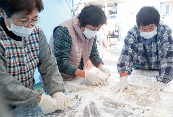 熱々の餅を手際よくちぎる地域住民（撮影・山北）