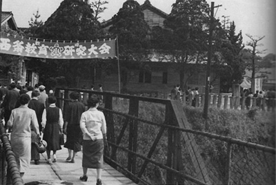黒橋を渡り小学校に向かう参加者