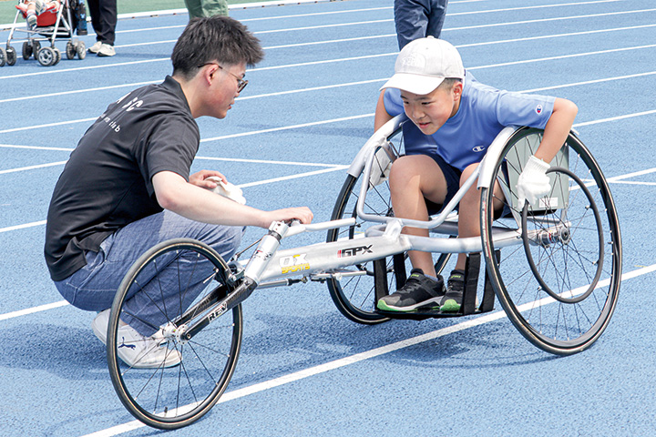 競技用車いすでレーサー体験をする参加者（撮影・加藤）