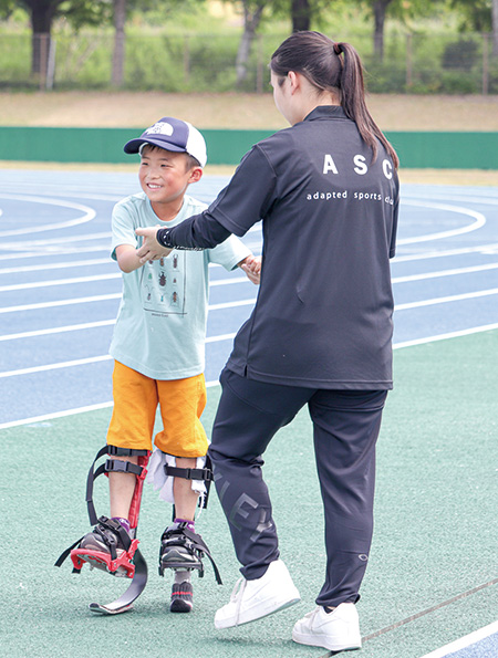 体験用の競技用義足で歩く参加者（撮影・加藤）