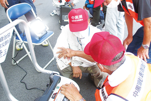 ガス発電機(左下)とワークライトの使い方講習会。小型で移動もしやすい(提供写真)