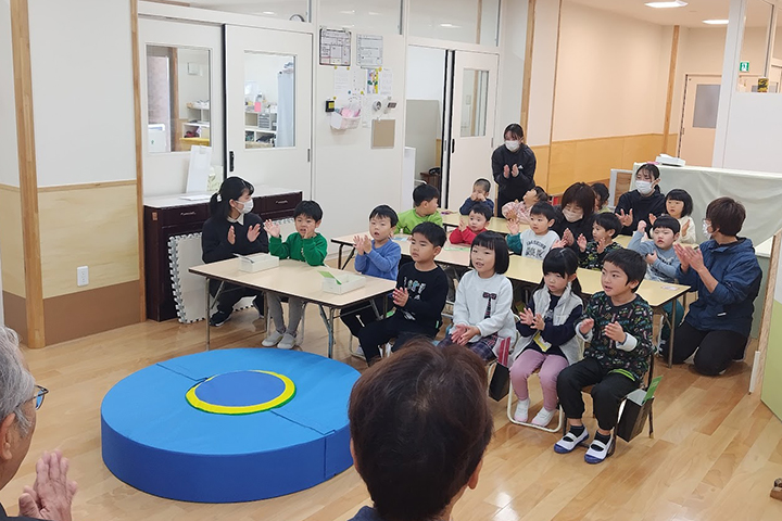 トランポリンの前で元気よく歌を披露する園児ら