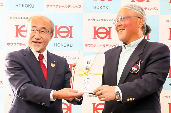 目録を手に笑顔で記念撮影に臨む金谷社長（右）と冨永会長