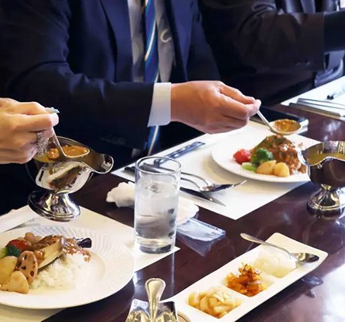 野菜トッピングにとりひき肉カレーをかけて食べる参加者（撮影・𦚰）