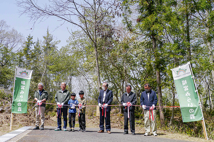 「福富みらいの森」森開きの会でテープカットする西山所長(左)、高垣市長(左から2番目)ほか地域住民(撮影・児玉)
