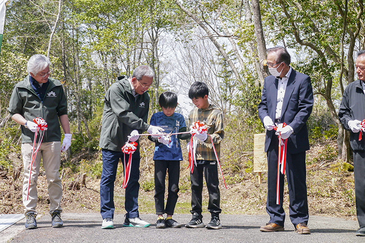 福富小学生のテープカットを補助する高垣広徳市長(撮影・児玉)