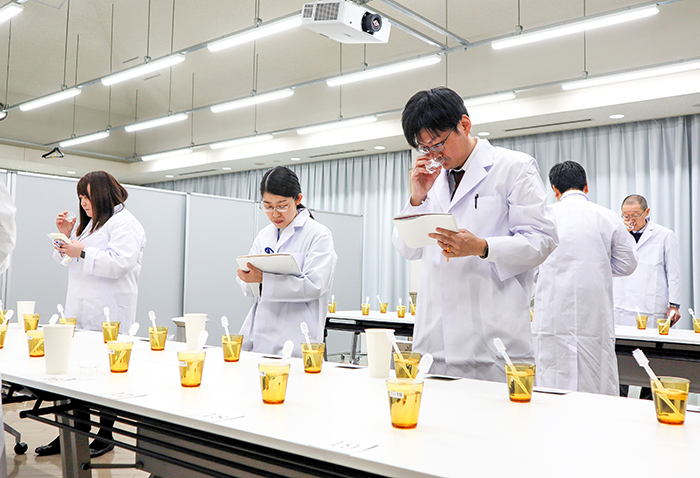 酒を口に含み、香味の調和や香り、味の良さなどを審査する研究員ら(山北)