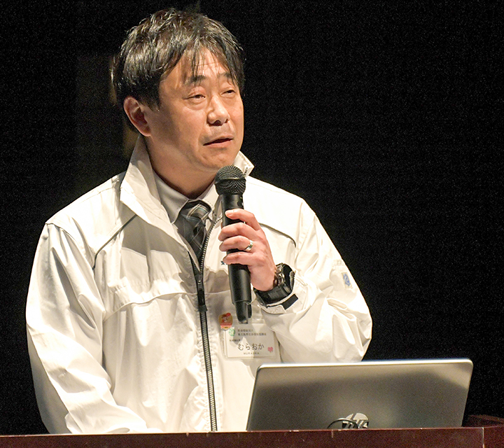 シンポジウムで発表を行う市社会福祉協議会・邑岡徹哉課長