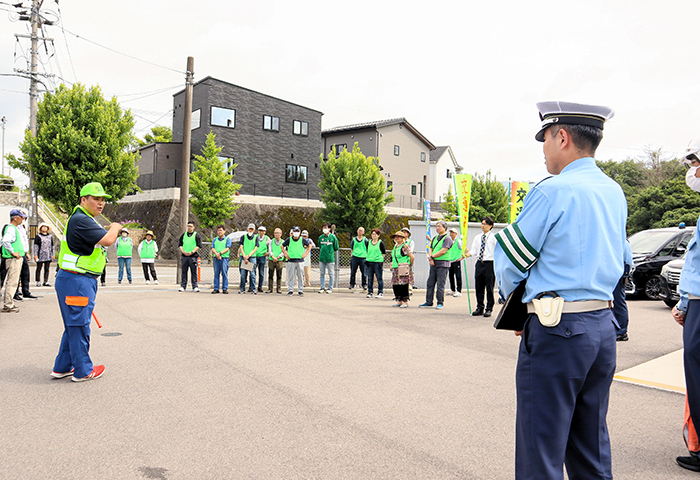 参加者に交通安全啓発活動の手順などを説明する中居防災・防犯部会長(左)(撮影・山北)