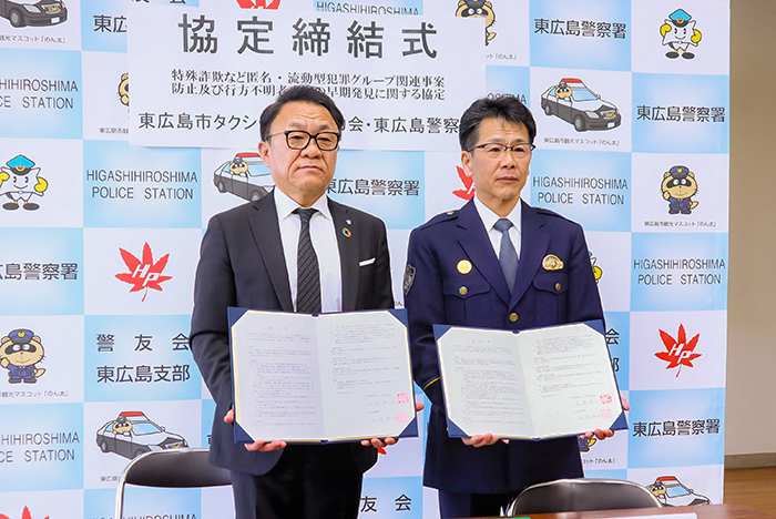 署名を終え協定書を手にする大野署長(右)と山田会長(撮影・山北)
