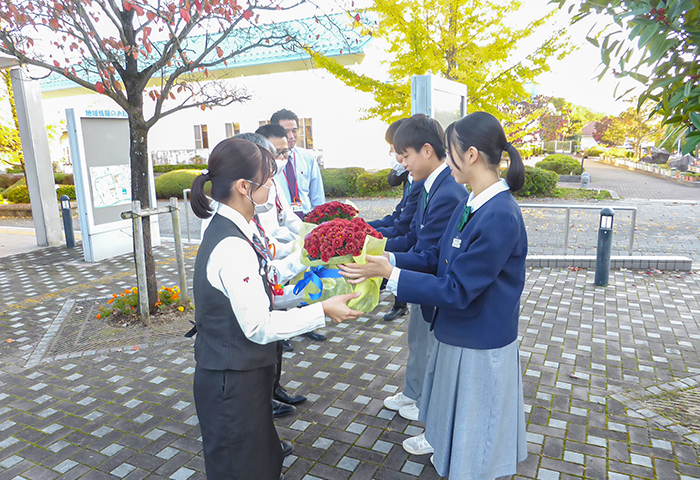 郵便局員に苗から育てたクッションマム(菊花)をプレゼントする生徒ら(提供写真)