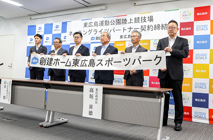愛称の「創建ホーム東広島スポーツパーク」を披露する関係者ら