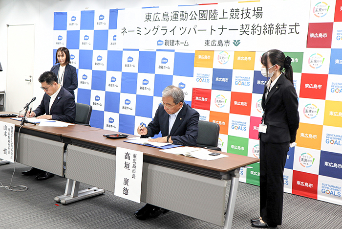 協定書にサインする高垣市長（右から2番目）と山本代表取締役