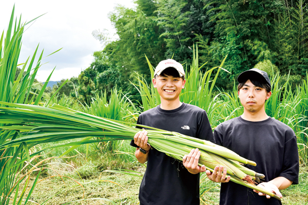 収穫したマコモダケを持つ住川浩輝さんと兄の貴志さん（29）