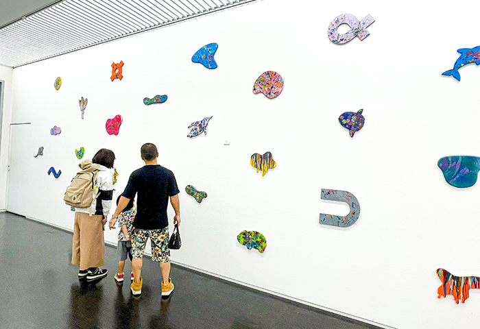 ボルタリングをイメージし、らふの子どもたちが色を施したカラフルなプレートを壁一面に展示