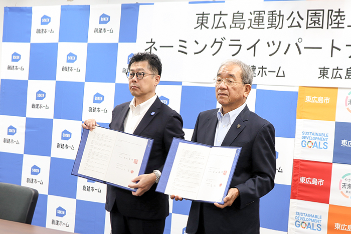 締結式で協定書を披露する高垣市長（右）と山本代表取締役