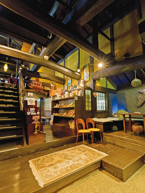 梁が交差する吹き抜けの玄関。木のぬくもりとやわらかな照明が、古民家ならではの落ち着きを醸し出す