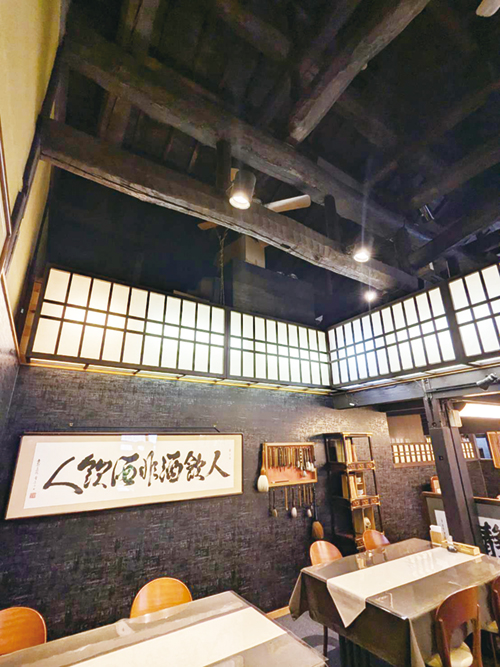 吹き抜けの天井に太い梁がわたる店内