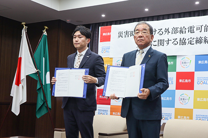 協定書を手に記念撮影する高垣市長（右）と橋本社長