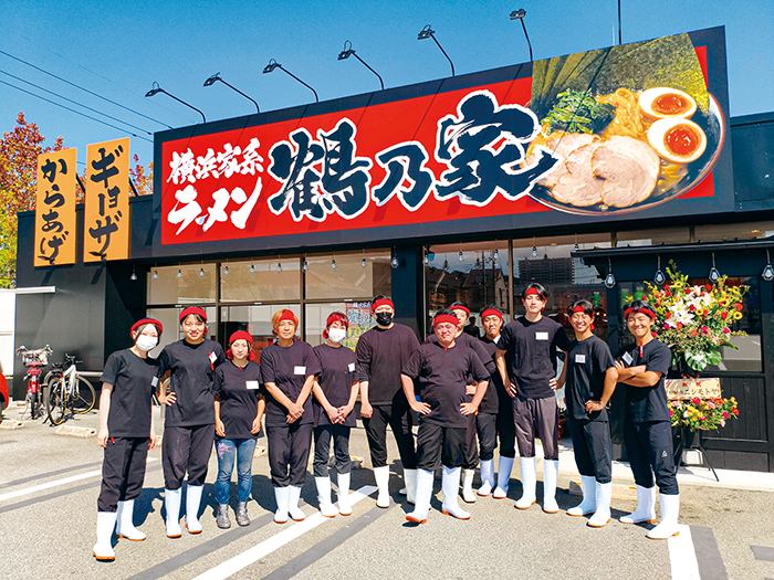 店舗前で記念撮影するスタッフ