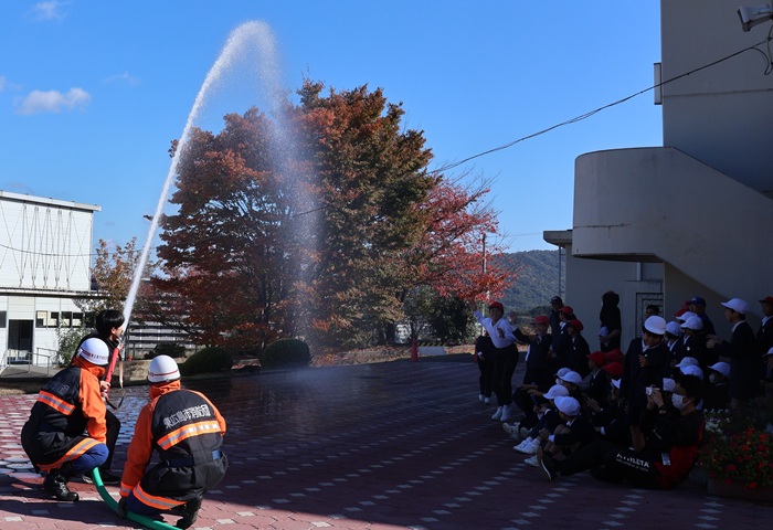 東広島市消防団による放水実演。児童たちから歓声が沸いた（撮影・𦚰）