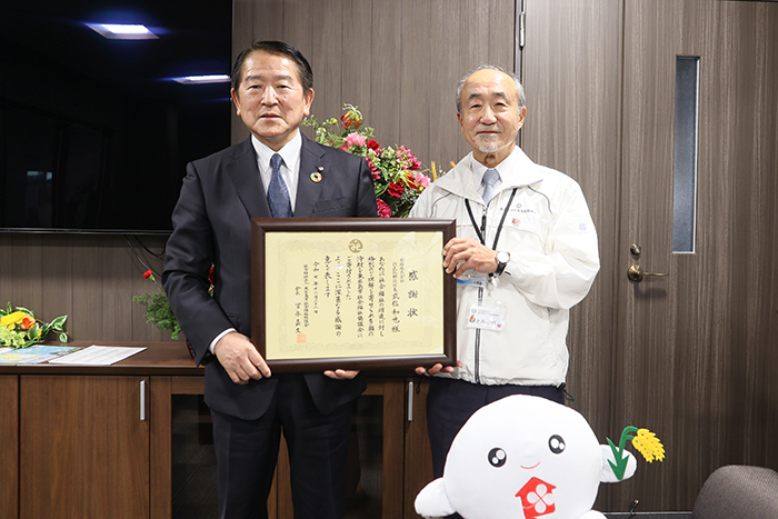 感謝状を手に記念撮影に応じる武信社長（左）と冨永会長（撮影・山北）